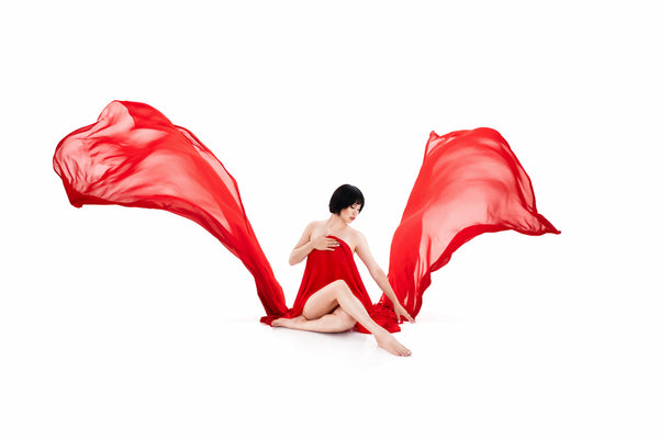 High-key dynamic image from the Self-Love Collection, individual in red with billowing fabric, creating a sense of movement and freedom